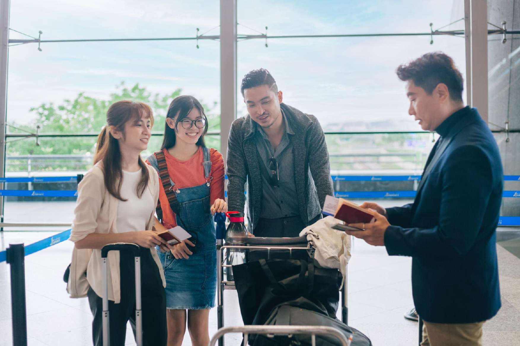 Friends with passports and luggage at airport check-in