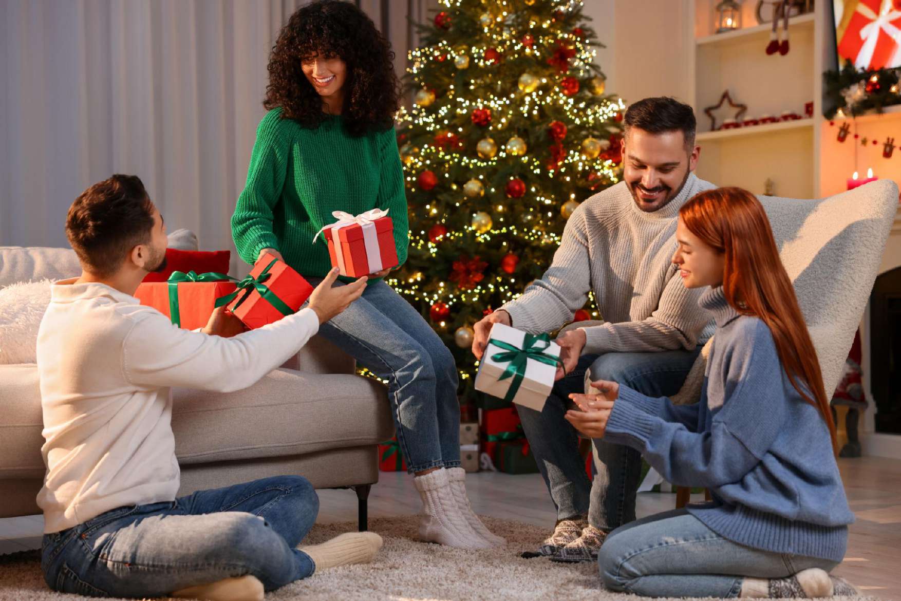 Friends exchanging gifts by a Christmas tree