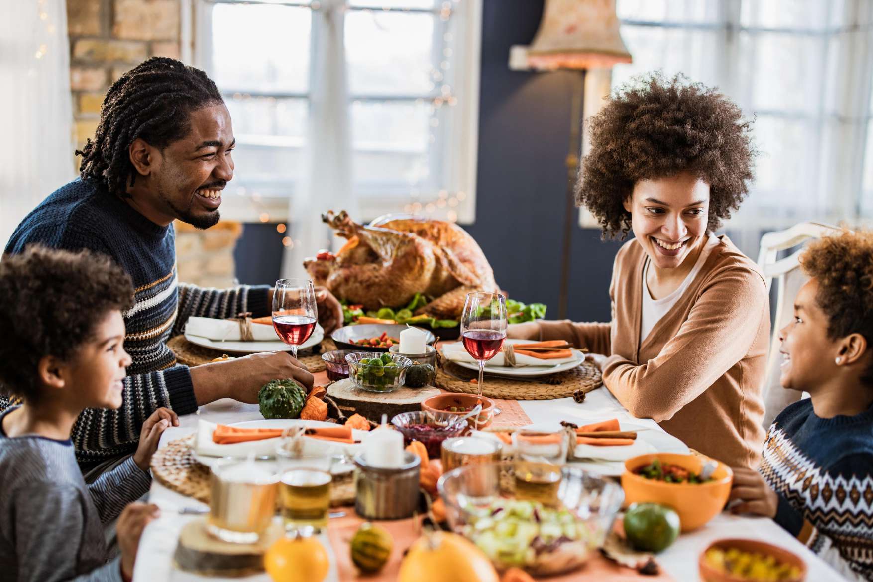 A family laughing around a holiday dinner table